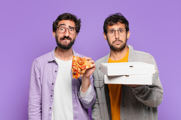 couple of hispanic friends sad expression and holding take away pizzas