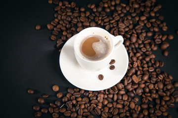 cup of coffee with coffee beans on black background