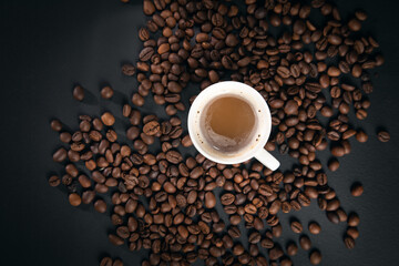 cup of coffee with coffee beans on black background