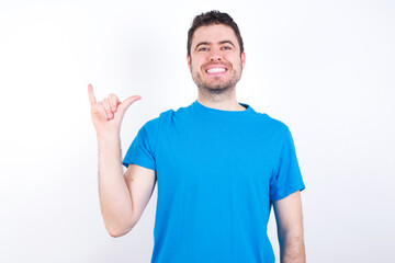 young handsome caucasian man wearing blue t-shirt against white background showing up number six Liu with fingers gesture in sign Chinese language