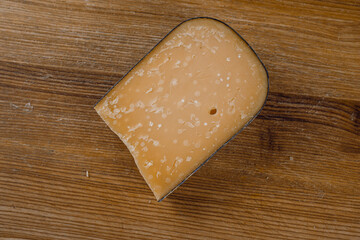 Parmesan hard aged cheese on wooden background. Snack tasty piece of cheese for appetizer
