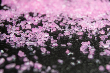 Obraz premium Pink salt on a black stone texture