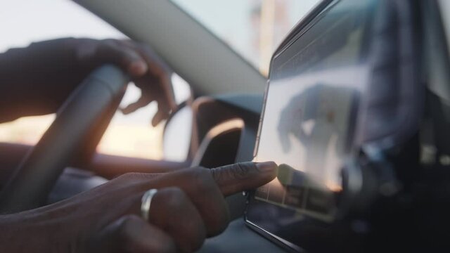 Close up of black man hand typing on the tablet in an electric car. High quality 4k footage
