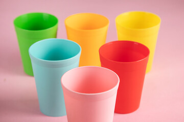 color plastic cups on pink background