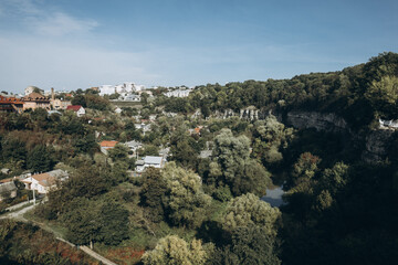 Canyon with river Smotrych, green trees and buildings. Historic part of Kamianets Podilskyi city. Ukraine