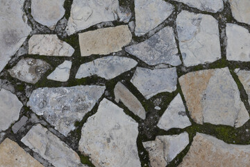 Background from stone white, gray and beige paving stones and earth