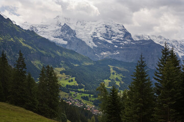 Fototapeta premium Clouds over the Jungfrau and its glacier (the Giesengletscher), with the village of Wengen below: Bernese Oberland, Switzerland