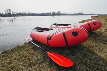 Red packraft rubber boats on the river bank. Selective focus. Active lifestile concept.