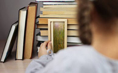 Smart cute girl opening a tiny door in the house of books, beam of lights through the door, studio shot, study and education concept