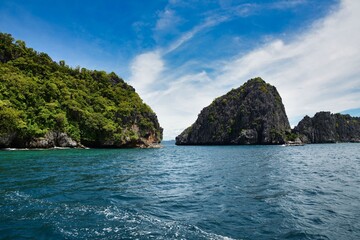 Fototapeta na wymiar El Nido Palawan dive spot in the Philippines, Island hopping, rock in the ocean, blue cloudy sky, fantastic view, sun