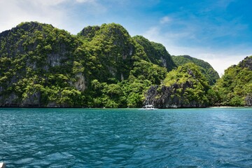 Fototapeta na wymiar El Nido Palawan dive spot in the Philippines, Island hopping, rock in the ocean, blue cloudy sky, fantastic view, sun