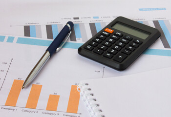Profit bar chart, pen, notepad and calculator