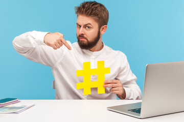 Serious bearded man smm manager pointing finger at hashtag sign, teaching social media management...