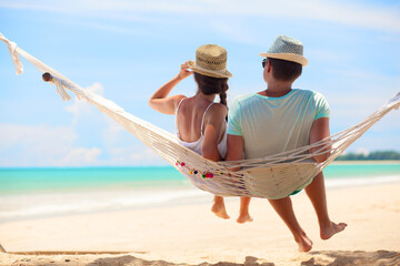Young romantic couple relaxing in hammock on tropical beach in Thailand