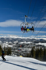 Fototapeta na wymiar People riding ski chair lift at Breckenridge, Colorado