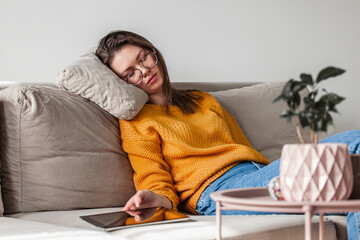 Young woman sleep on sofa using digital tablet