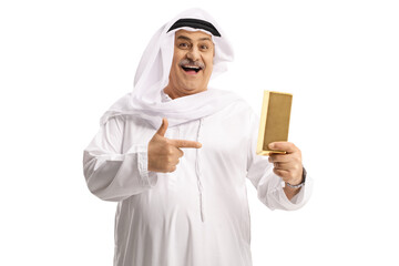 Happy mature arab man holding a gold bar and pointing