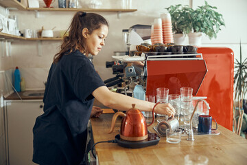 Barista giving order to client at the trendy coffee shop. Pouring water in glass