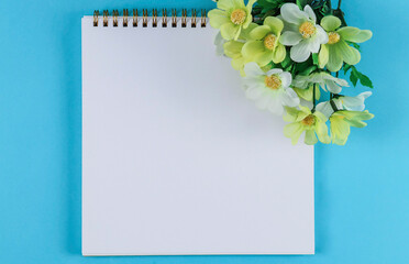 Notebook with flowers on a blue background.