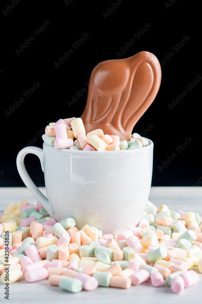 Wall mural Background of spring easter celebration birth festival season with colorful sweet confectionery milk chocolate egg and rabbit bunny ear on marshmallow nest