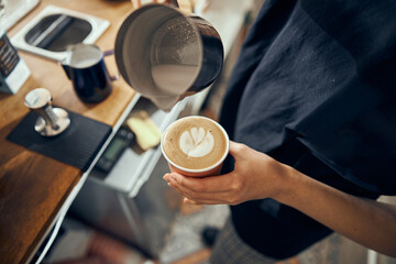 Fototapeta na wymiar Barista making cappuccino, bartender preparing coffee drink. Coffee cup with latte art