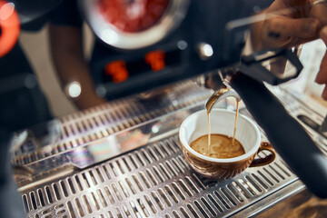Close-up of espresso pouring from coffee machine. Professional coffee brewing