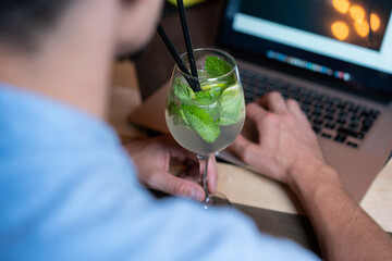 Man working on laptop and drinking bio lemonade on the table