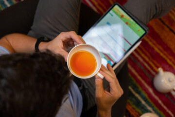 Fototapeta na wymiar Man drinking tea near tablet