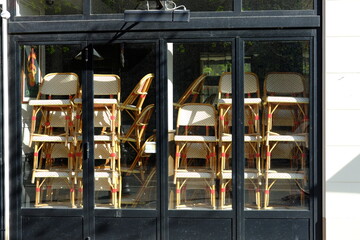 Some chairs stacked at a closed parisian bar during the covid-19 pandemic.