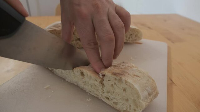 Hands cut typical bread from Madeira called bolo do caco. Handheld shot