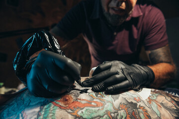 Obraz premium Tattoo artist creating a tattoo