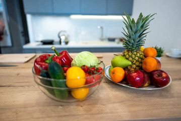 Fruits And Vegetables On The Table Of Modern Kitchen Choice between fruits and vegetables on the table of modern kitchen. Vegan nutrition