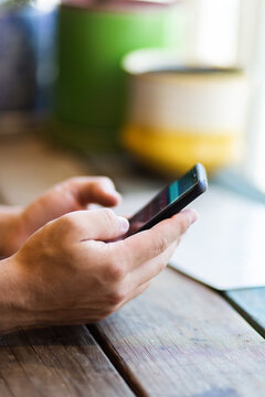 Man sitting at a table using his phone while waiting for food