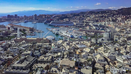 Fototapeta premium Aerial panoramic drone view of buildings and streets surrounding Port of Genoa.Cruise ship in port.