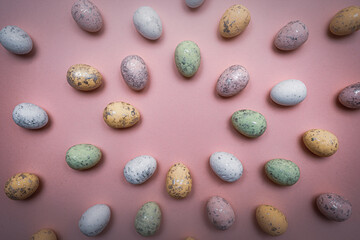 Colorful Easter eggs directed towards the center on purple background. Spring holidays concept