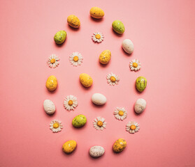 Colorful Easter eggs and flowers form a egg on purple background. Spring holidays concept