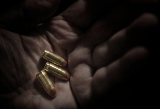 Close-up of hand holding bullets