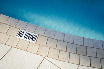 Warning sign at edge of swimming pool