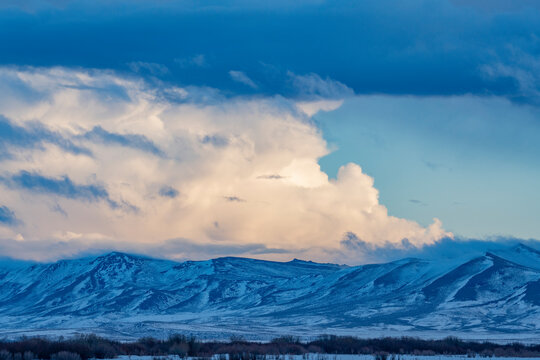 USA, Idaho, Fairfield, Snow dusted mountains and clouds over prairie