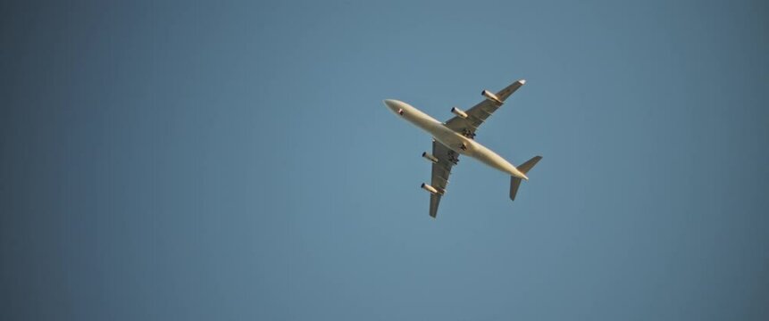 An airplane flying up high in the sky, close up, low angle view. Slow motion.