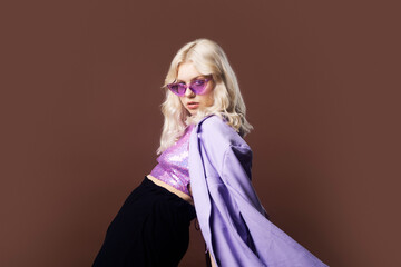 A girl in a purple jacket on a brown background in 70s, 80s, 90s style makeup, long silver...