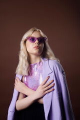 A girl in a purple jacket on a brown background in 70s, 80s, 90s style makeup, long silver...