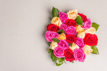 Composition of fresh multicolored roses on ceramic stand