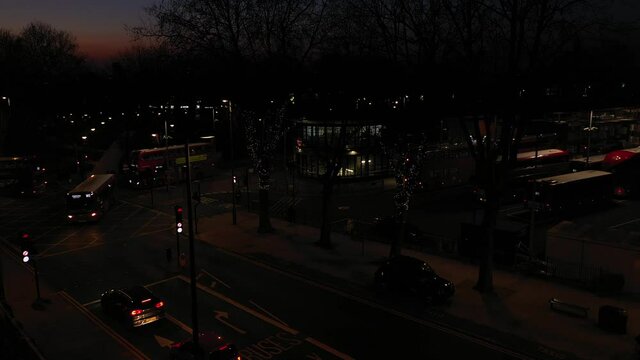 LOW ANGLE SLIDE PAN OF LONDON BUSY BUS STATION AT SUNDOWN