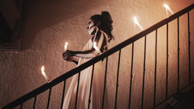 Hispanic woman with a bride dress and a body paint of an skeleton during the day of the death for a celebration in Mexico. 4k