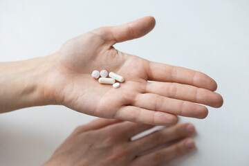 a woman's hand with pills in the open palm, covid medicines or vitamins to promote a woman's health during pregnancy or a period of avitaminosis