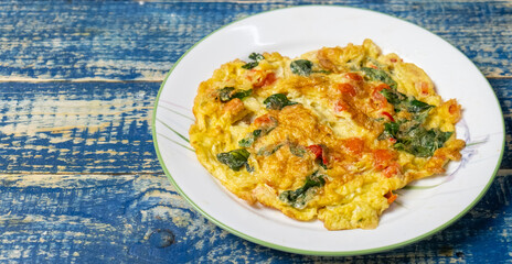 Thai egg omelette or locally known as Kai Chiao over wooden background. Selective focus.