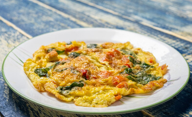 Thai egg omelette or locally known as Kai Chiao over wooden background. Selective focus.