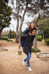 Obraz premium Young girl climb on the back of her boyfriend, piggyback, having fun