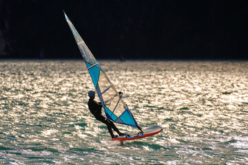 Windsurfer surfing the wind on waves In Garda Lake, riders surfing at high speed on Lake Garda,...